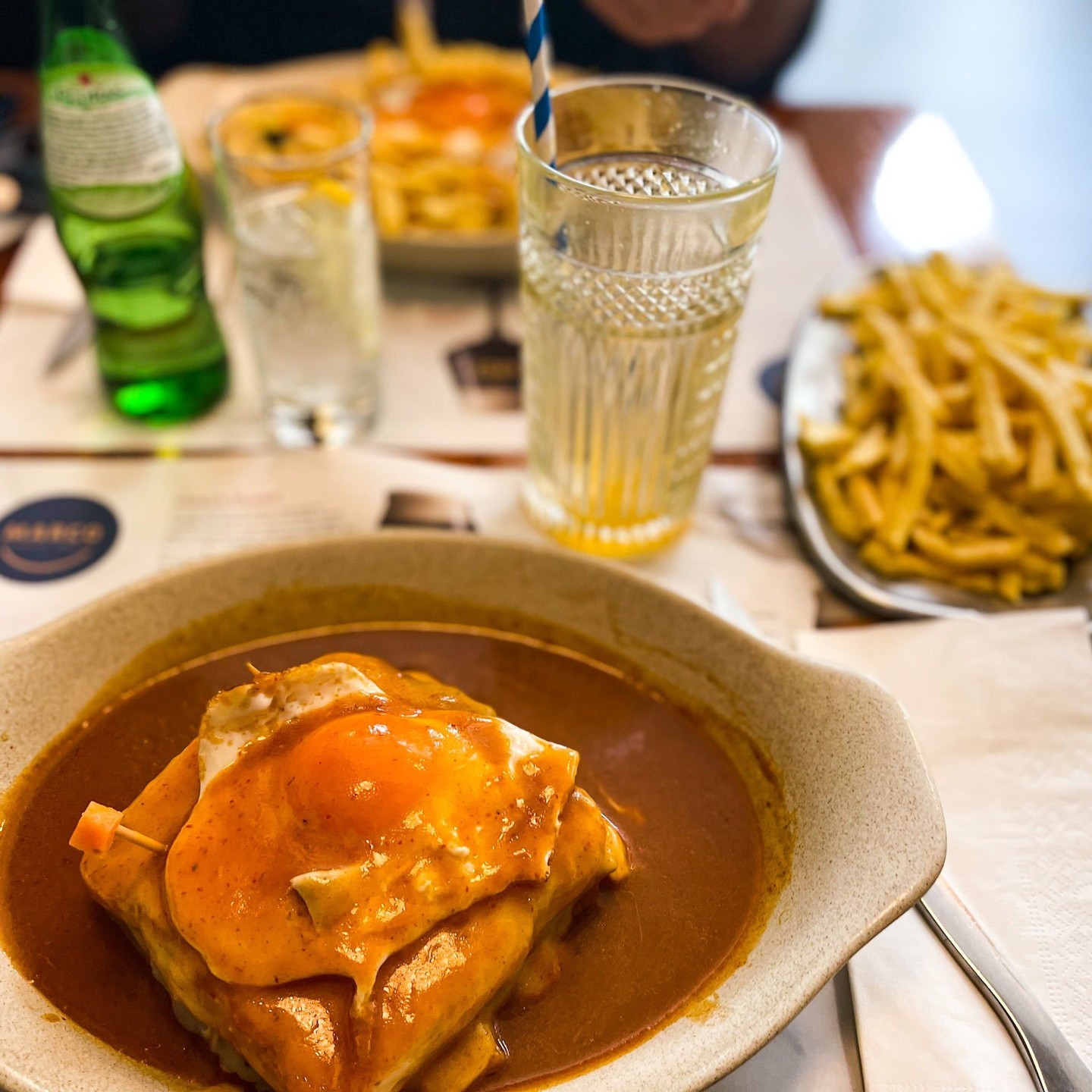 Francesinha. This is a Portuguese sandwich, although it's from further north in the city of Porto.?
?
It's made with bread, many layers of meats (such as wet-cured ham, linguiça, fresh sausage, steak, roast meat) covered with melted cheese and a hot, thick, spiced beer sauce. ?
?
Then, if that wasn't enough richness, meat, and cholesterol, it's served over french fries with an egg on top. ?
?
It's an important dish here in Portugal, and gives a pretty accurate view of how meat-centric Portuguese food can often be. ?
?